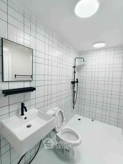 Modern minimalist bathroom with sleek fixtures and white tile design.