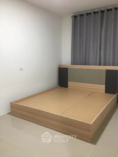 Minimalist bedroom with modern bed frame and neutral curtains