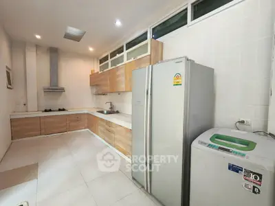Modern kitchen with sleek appliances and wooden cabinetry in a spacious layout.