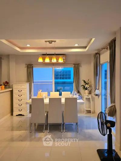 Elegant dining area with modern lighting and sleek white furniture
