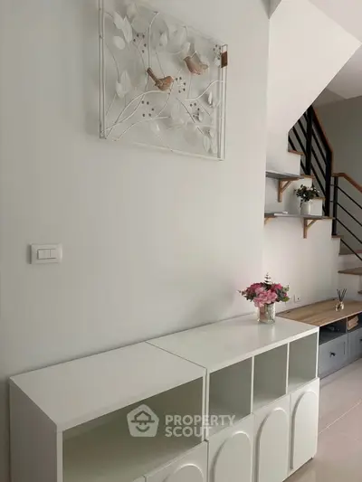 Modern interior with stylish staircase and decorative wall art in a bright living space.