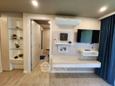 Modern living room with wall-mounted TV and air conditioning, featuring sleek storage solutions.