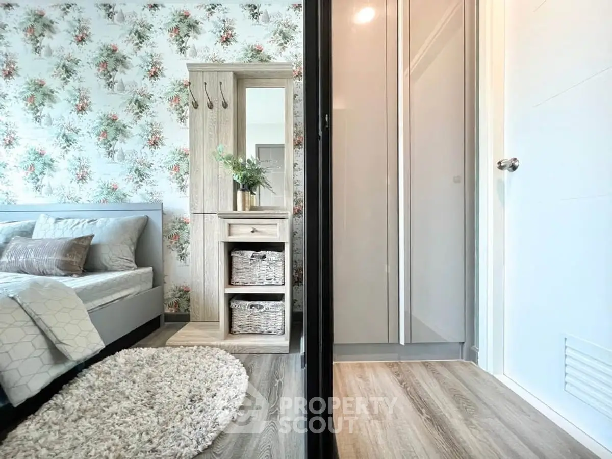 Charming bedroom with floral wallpaper and modern decor adjacent to a sleek bathroom.