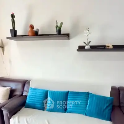 Cozy living room with modern decor and vibrant blue cushions.