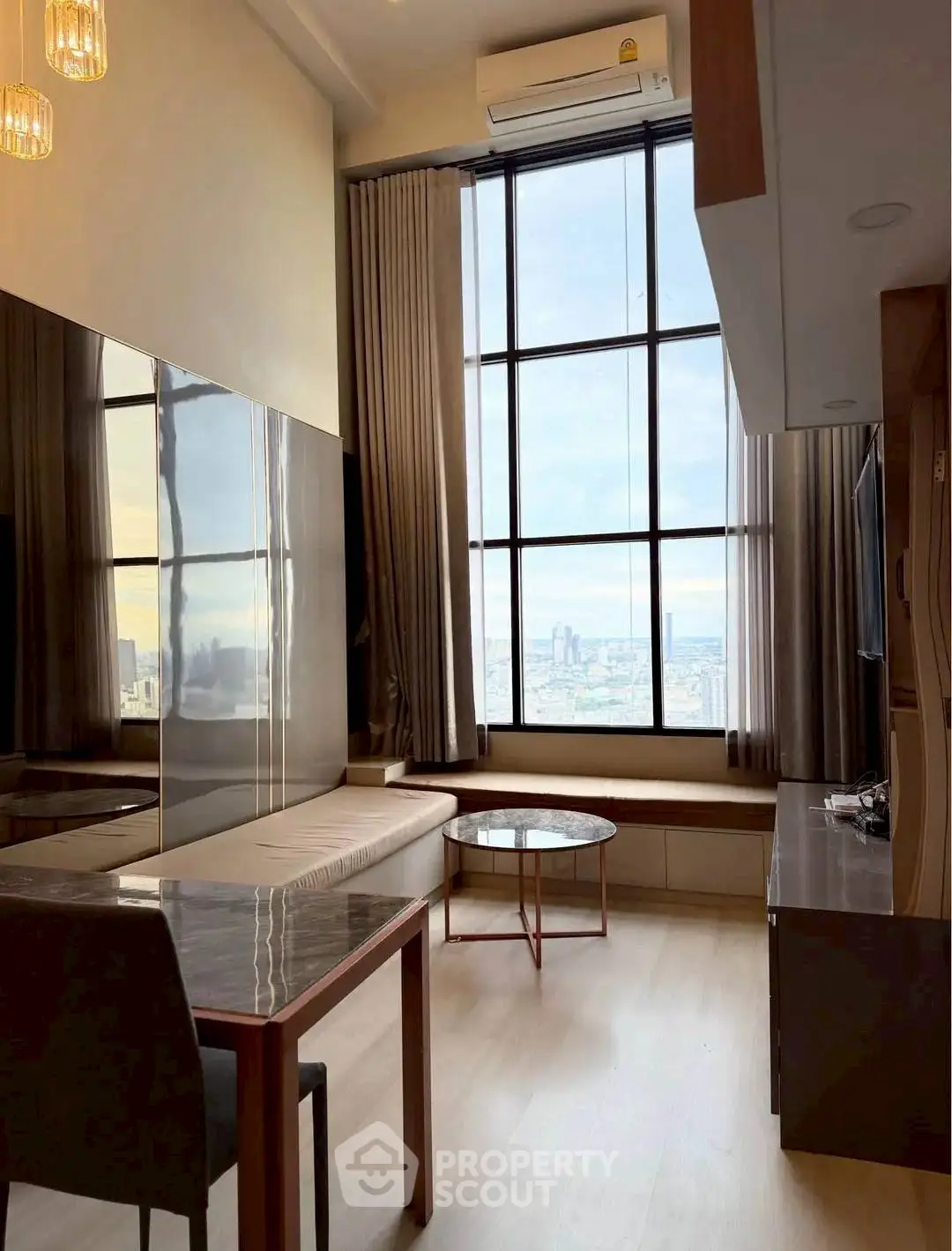 Luxurious high-rise living room with floor-to-ceiling windows and stunning city view.