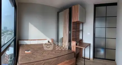 Modern bedroom with large window and stylish wooden furniture in a high-rise apartment.
