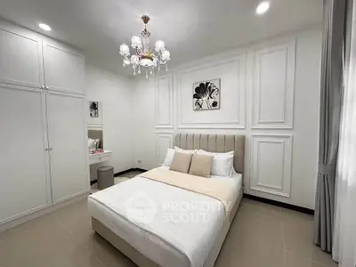 Elegant bedroom with chandelier and modern decor, featuring a cozy bed and built-in wardrobe.