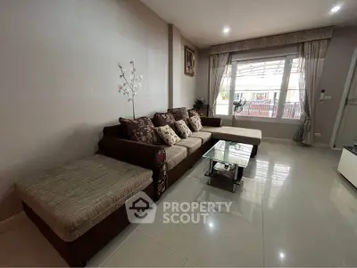 Spacious living room with elegant sofa and large window for natural light.