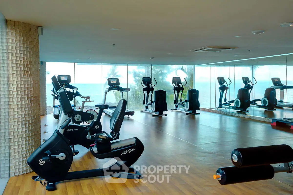 Spacious gym with modern equipment and ocean view for luxury fitness experience.