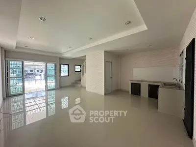 Spacious open-plan living area with modern kitchen and large windows for natural light.