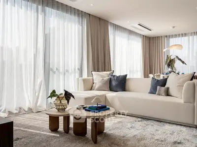 Luxurious living room with elegant decor and natural light, featuring a cozy white sofa and stylish coffee table.