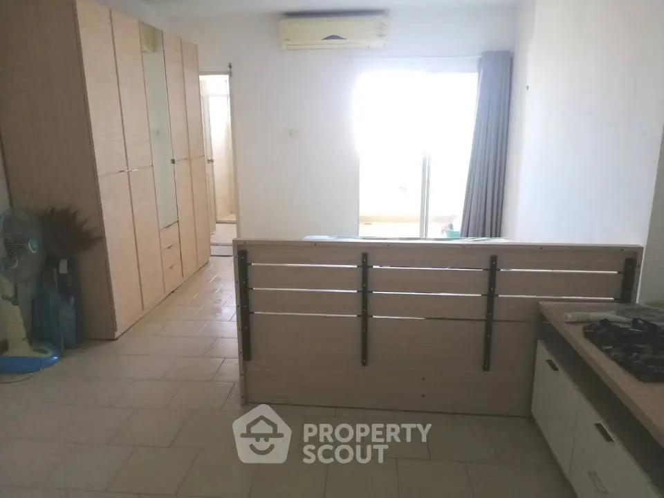 Spacious studio apartment with modern kitchen and ample storage space.