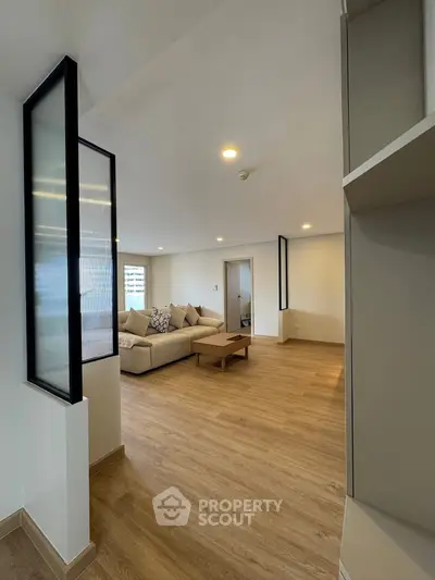 Spacious modern living room with wooden flooring and cozy seating area.