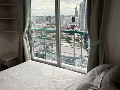 High-rise bedroom with stunning city view through large window.