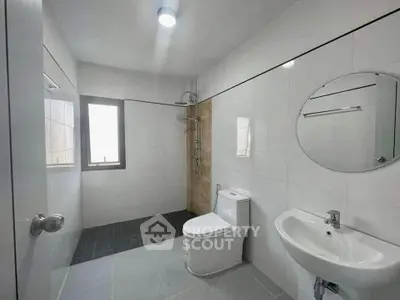 Modern bathroom with sleek fixtures and large window for natural light.
