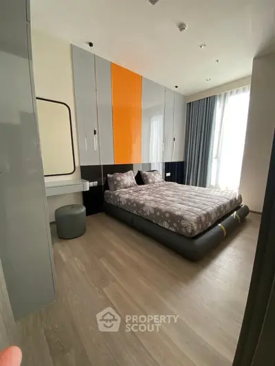 Modern bedroom with stylish decor and large window for natural light