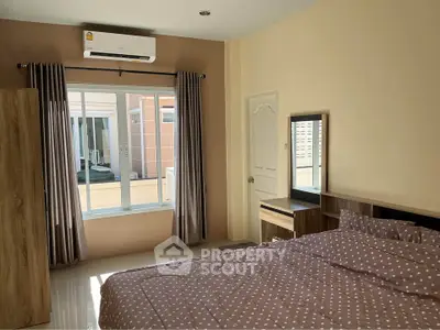 Spacious bedroom with natural light and modern furnishings in a cozy apartment.