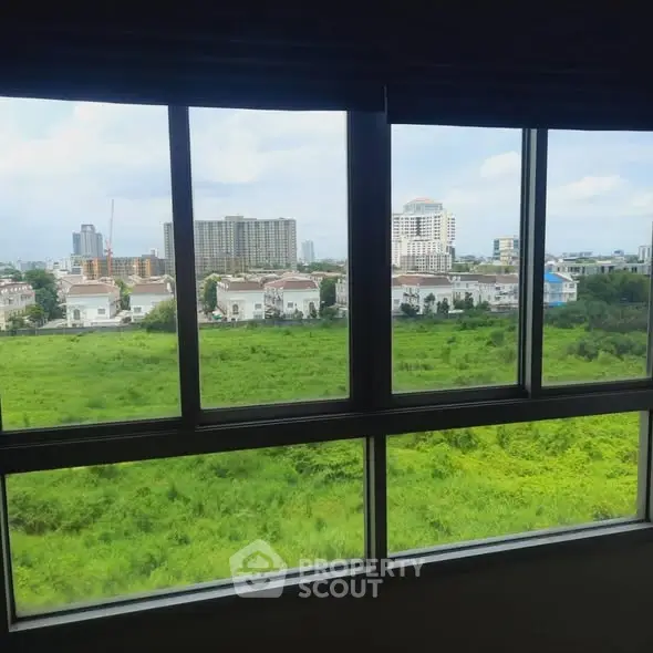 Stunning cityscape view from a large window in a modern apartment.