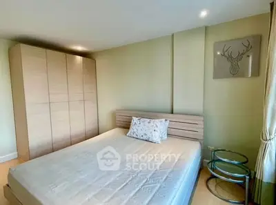Cozy bedroom with modern wardrobe and stylish decor in a serene setting.