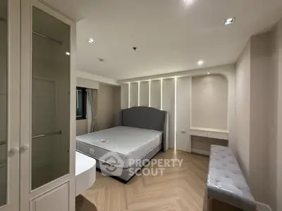 Spacious bedroom with modern design and elegant furnishings, featuring a comfortable bed and ample storage space.