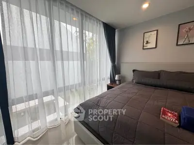 Cozy bedroom with large windows and modern decor, perfect for relaxation.