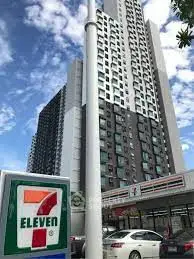 Modern high-rise building with retail space including a 7-Eleven store, urban living convenience.