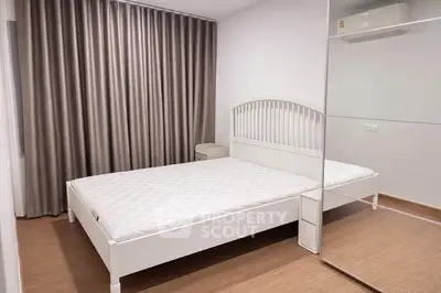 Modern minimalist bedroom with white bed and mirrored wardrobe