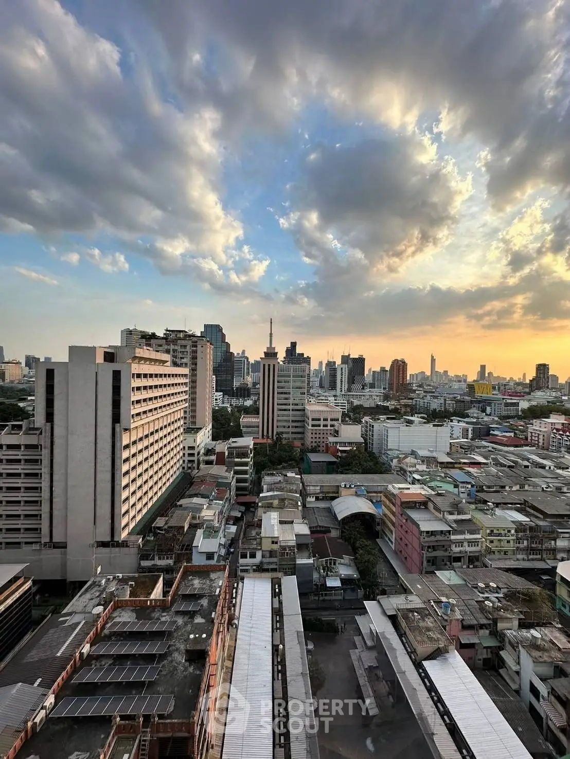 Stunning cityscape view from high-rise building at sunset, showcasing urban skyline and vibrant sky.