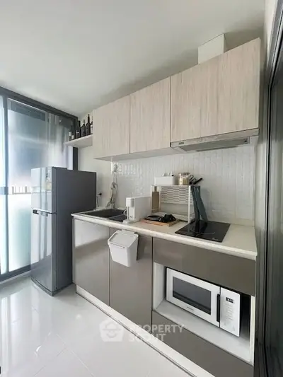 Modern kitchen with sleek cabinetry and appliances in a compact layout.