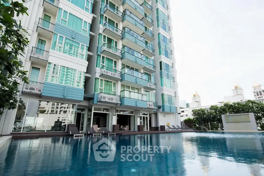 Luxurious high-rise building with stunning poolside view and modern architecture.