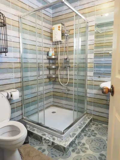 Charming bathroom with modern shower and rustic wood panel walls.