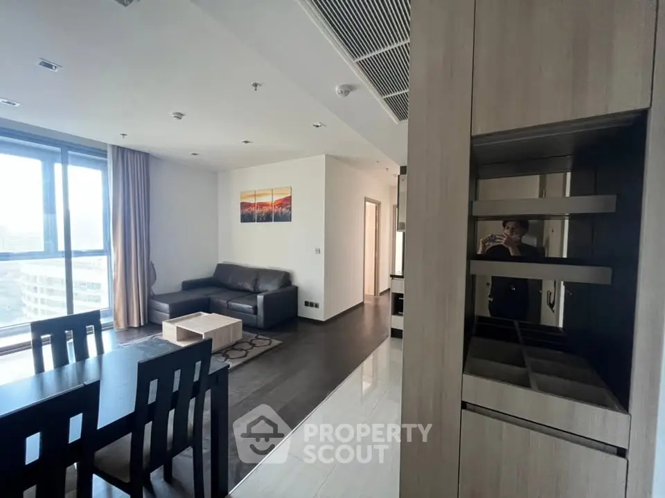 Modern living room with sleek furniture and large windows offering natural light.