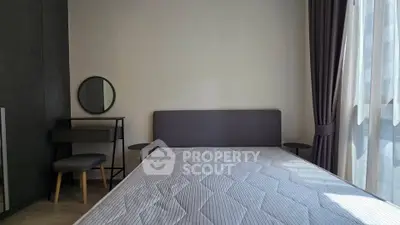 Modern bedroom with minimalist design and ample natural light from large window.