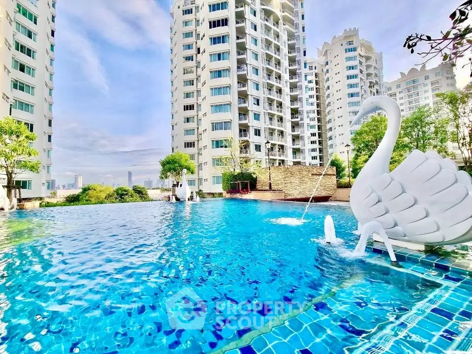 Luxurious apartment complex with stunning pool and swan float, perfect for relaxation.