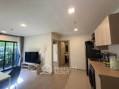Modern open-plan living room and kitchen with natural light and garden view.