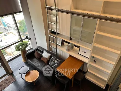Modern loft apartment with high ceilings, large windows, and stylish furniture in urban setting.