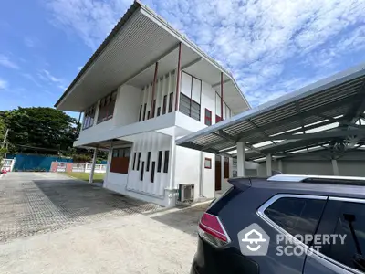 Modern two-story building with carport and unique architectural design