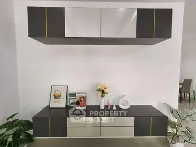 Modern living room with sleek black and white cabinetry and decorative accents.