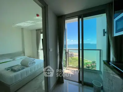 Luxurious bedroom with stunning ocean view from private balcony in modern apartment.