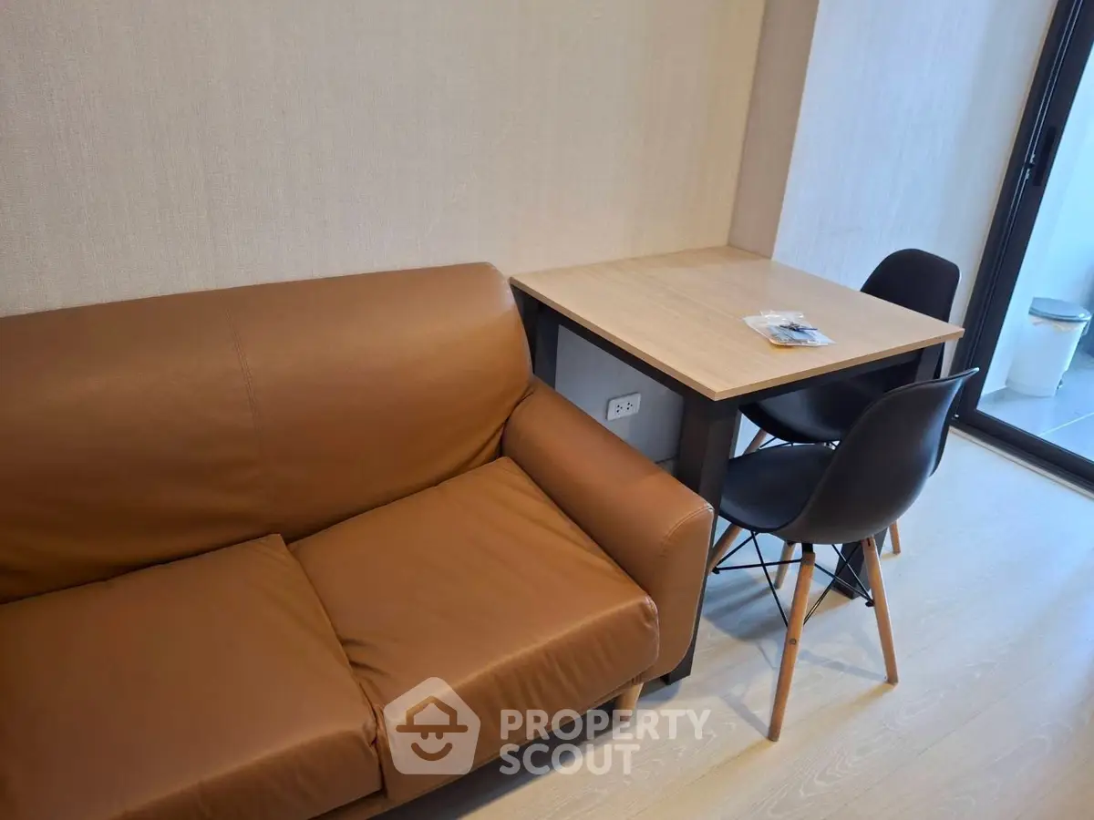 Modern living room with brown leather sofa and dining table in cozy apartment