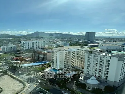 Stunning cityscape view from high-rise building with mountains in the background, perfect for urban living.