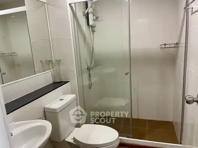Modern bathroom with glass shower enclosure and sleek fixtures