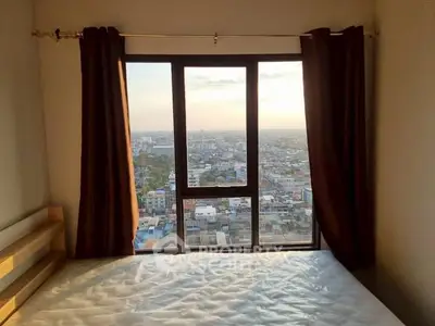 Stunning city view from a high-rise bedroom window with natural light.