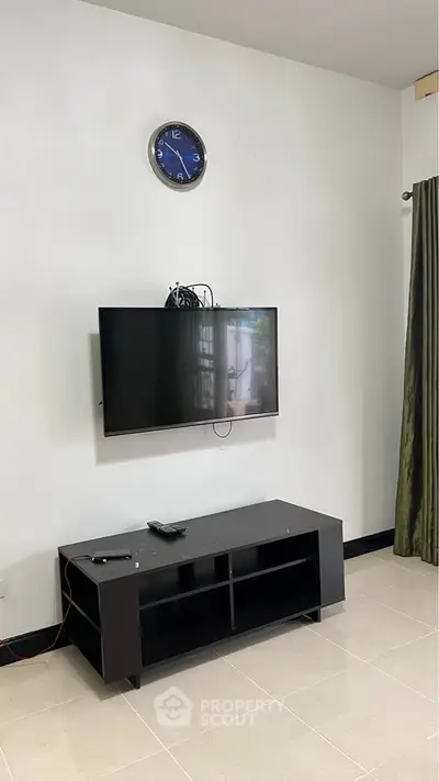 Modern living room with wall-mounted TV and sleek black console