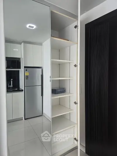 Modern kitchen with sleek cabinets and mirrored storage in contemporary apartment