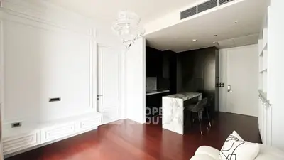 Luxurious modern living room with elegant white paneling and sleek kitchen area.