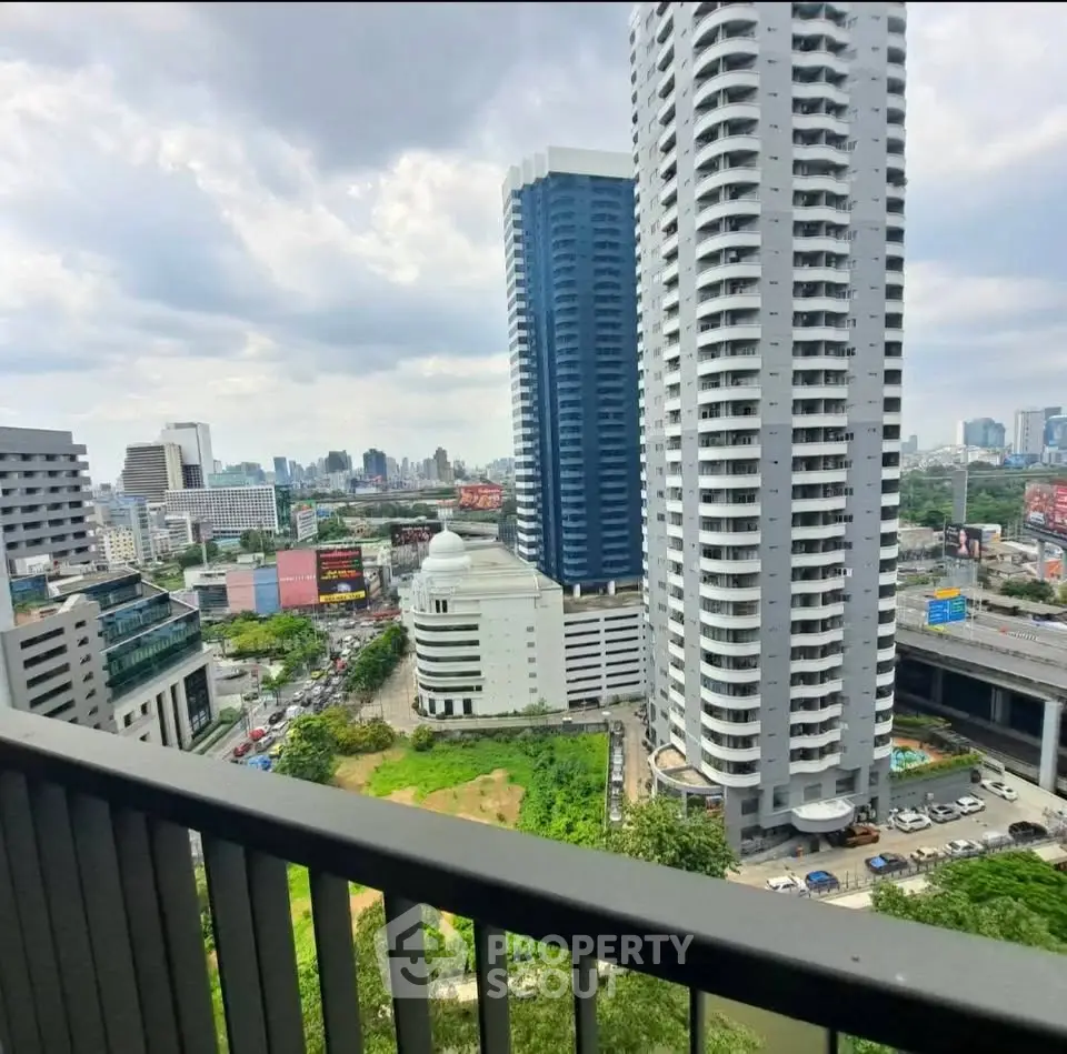 Stunning cityscape view from a high-rise balcony overlooking modern skyscrapers and lush greenery.