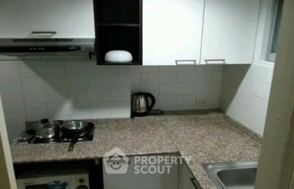 Compact modern kitchen with granite countertops and electric stove