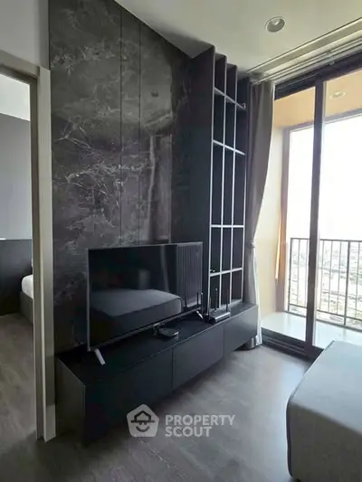 Modern living room with sleek black TV stand and large window balcony view