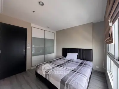 Modern bedroom with sleek design and ample natural light in a stylish apartment.